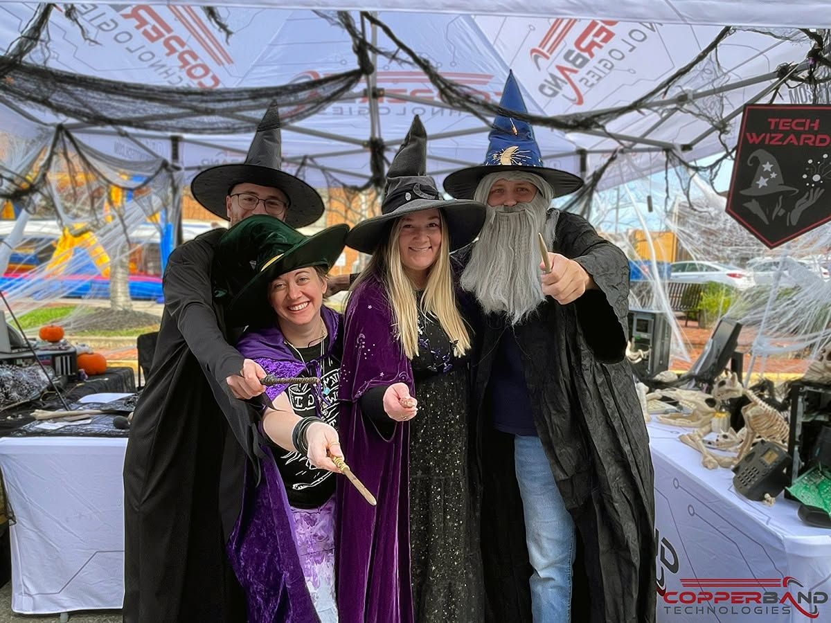 Four Copperband team members in wizard and witch costumes under the Copperband tent at Fright on Franklin