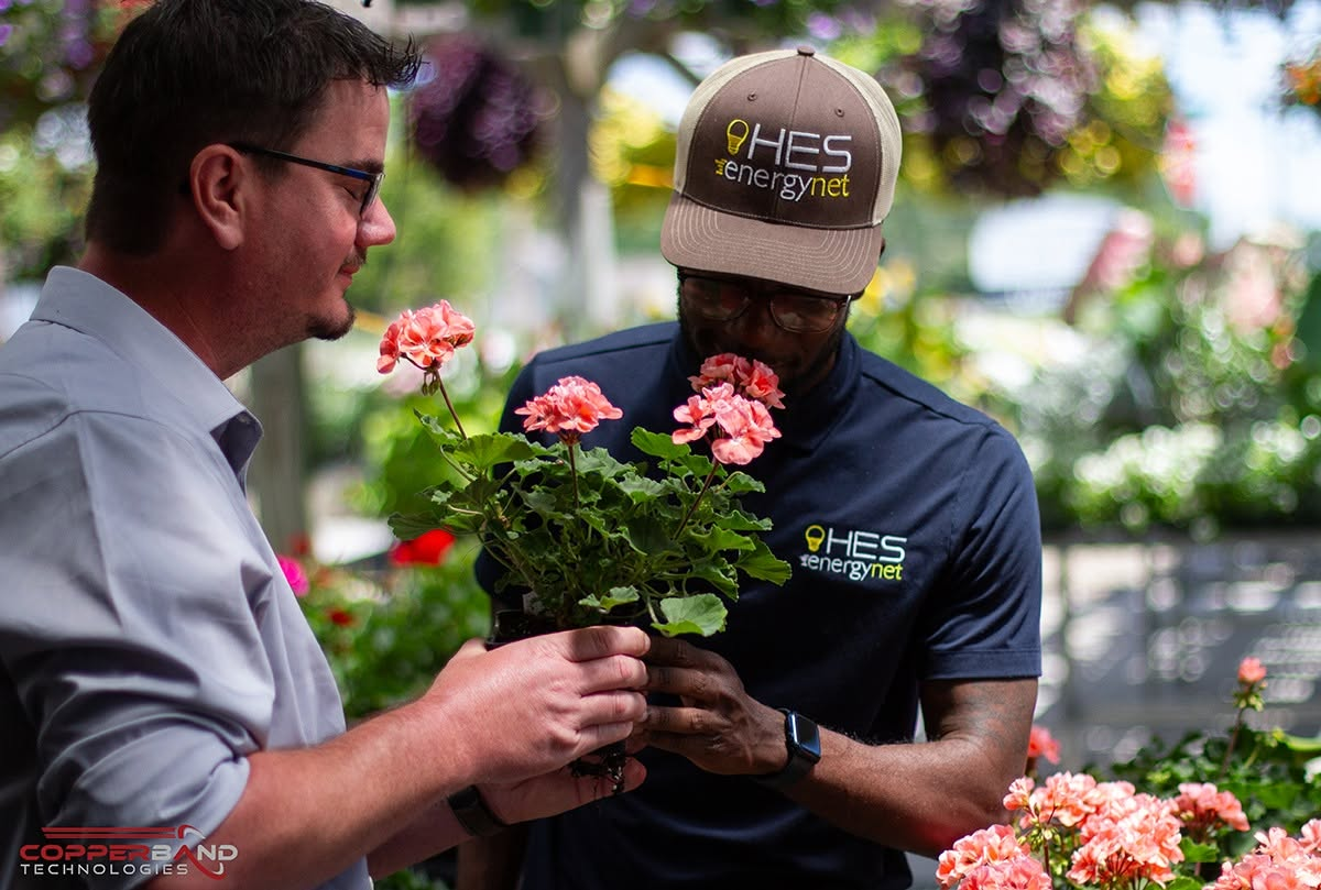 Two guests looking over geraniums in the greenhouse at Superlawn and Garden during the June 2026 Quality Service Award presentation