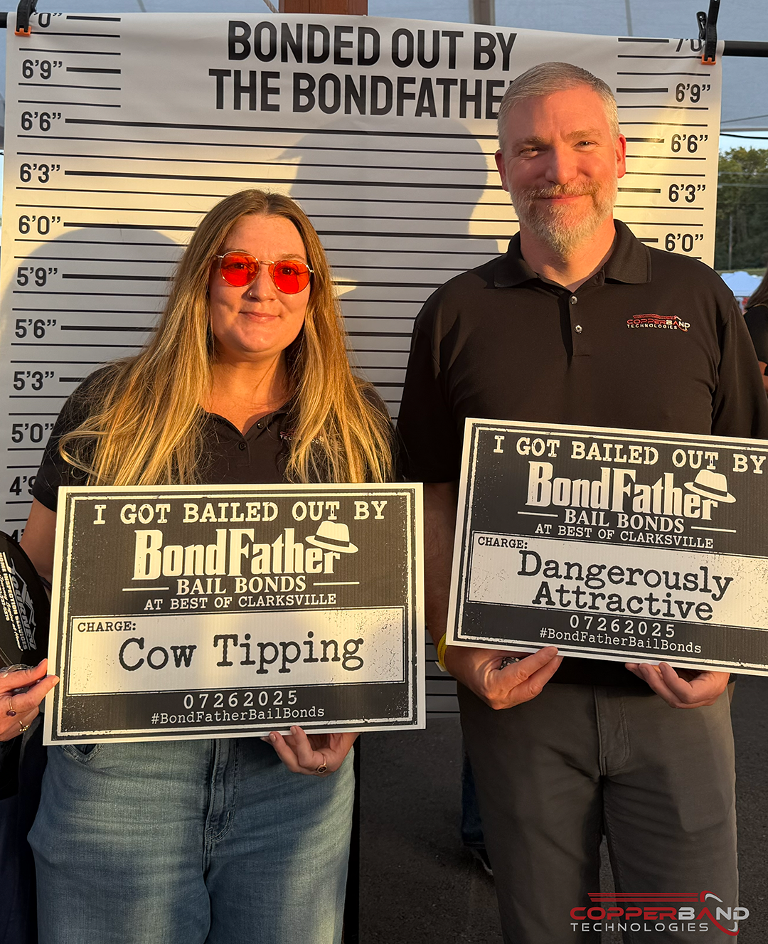 Two Copperband team members holding mugshot signs at the Best of Clarksville 2026 photo booth